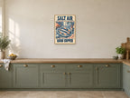Salt Air Good Supper — A2 artwork shown in a room with a natural wood frame; select a framed finish to include a frame