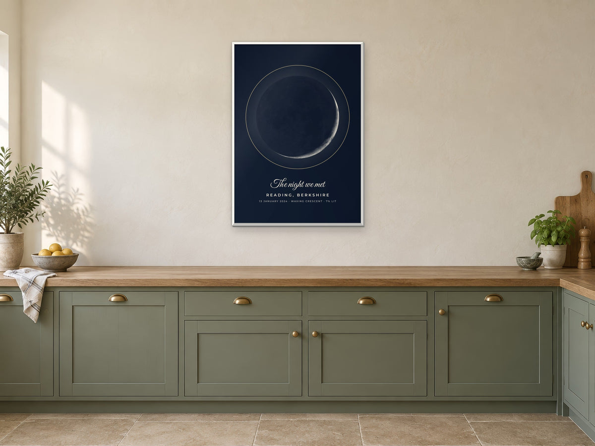 Moon phase poster of a crescent moon over Reading in the Midnight design, in a white frame, in a kitchen